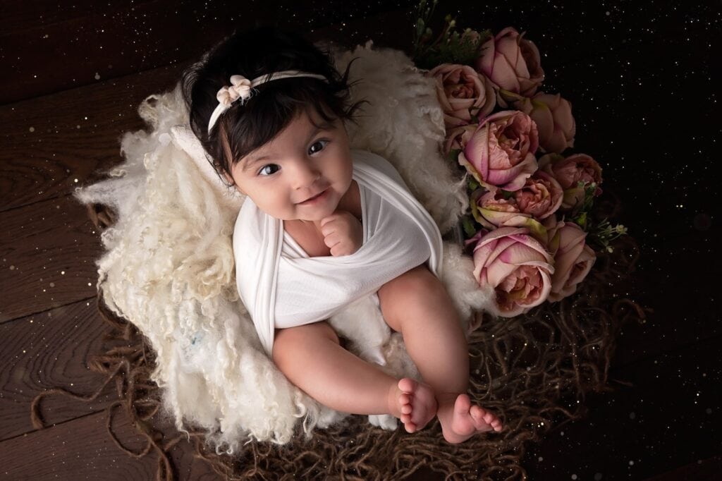Older newborn in bucket with flowers