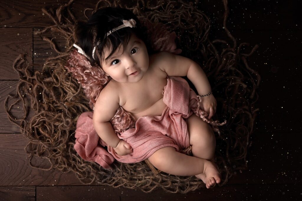 older newborn in pink with a beautiful smile