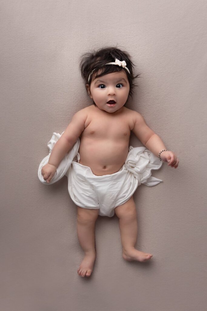 Older newborn in cute pose with sweet face