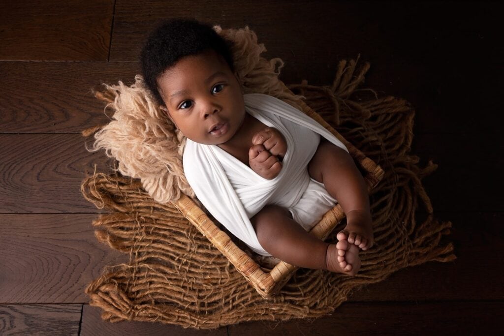Older newborn in white smiling