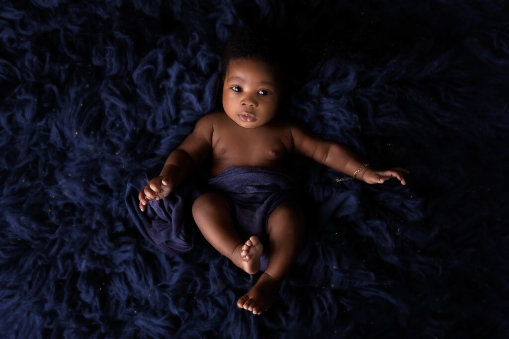Older newborn on blue rug