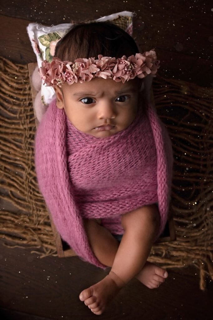 Older newborn with pink flower crown on head